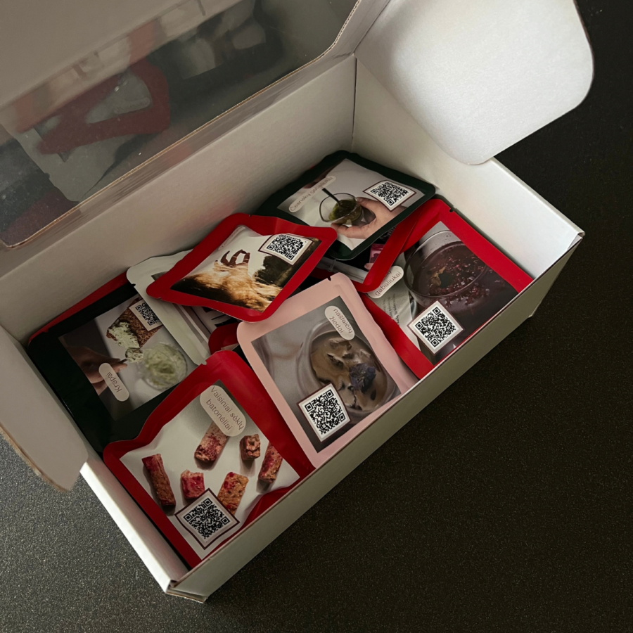 Liofilizuotų uogų, žolelių ir prieskonių mėginėliai su QR kodais atidarytoje baltoje dėžutėje
